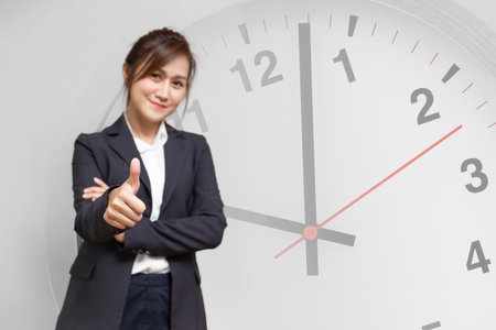 Business women thumbs up with clock face, Office people good timing working hours management to goal success conceptの写真素材