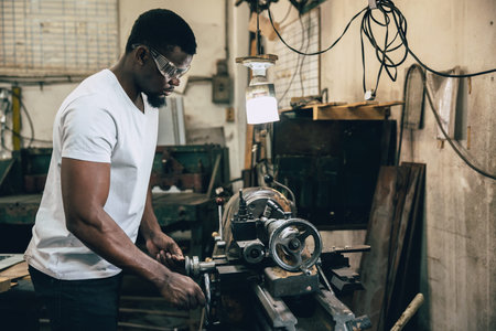 african black male professional worker working in heavy industry metal factory workshop using steel...