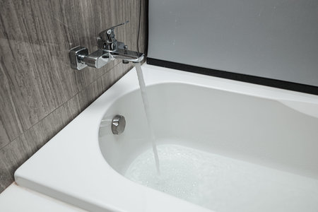 shower bath faucet is turned on and amount of water flows out added fill to the bathtub.