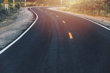clean newly build black asphalt road, two lane curve along way path forward at countrysideの写真素材