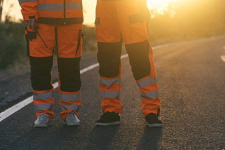 Engineer worker wearing safety suite walking survey inspect at new construction street road highway for final build quality check in sunsetの写真素材