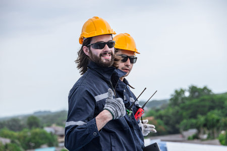 Happy engineer worker team standing thumbs up wearing groove safety suit hardhat work at height...