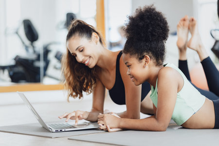 Healthcare Online Training. Young Fit Woman with child Exercising at Gym Sport club, Watching Video...