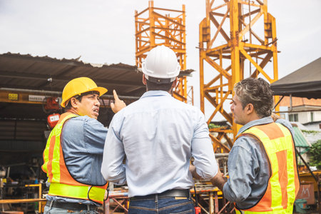Construction engineer team working together join teamwork control operate tower crane at...