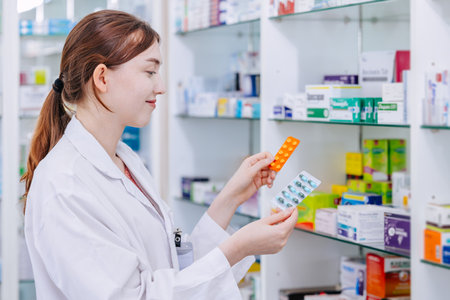 Pharmacist doctor holding mix type medicine pack compare selection or choice medicine in pharmacy drugstore.の写真素材