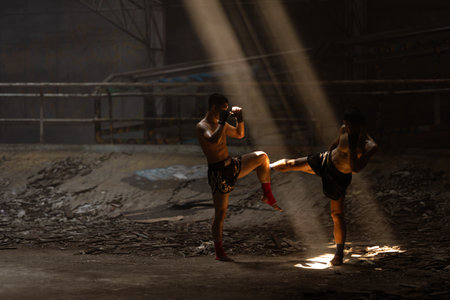 Muay Thai, Asian young male Bare Knuckle Fighting street kick boxing fighters fighting action, Thai fight boxing in dark old buildingの写真素材