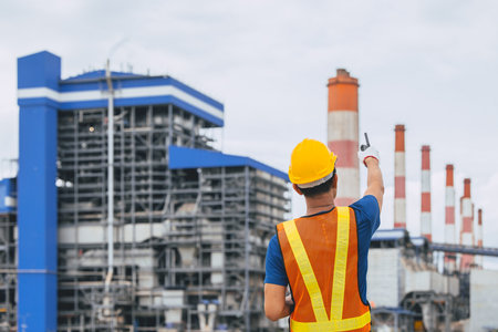 Professional engineer male worker with coal power plant, Power station with green nature background