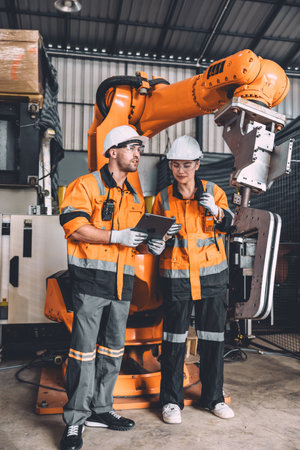 Engineer team service robot welding working in automation factory. People workers safety work control robot machine in heavy industry technology.の写真素材