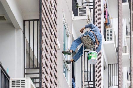 Exterior paint and leak repair technician builder, rope rappelling to repair buildings outside crack...
