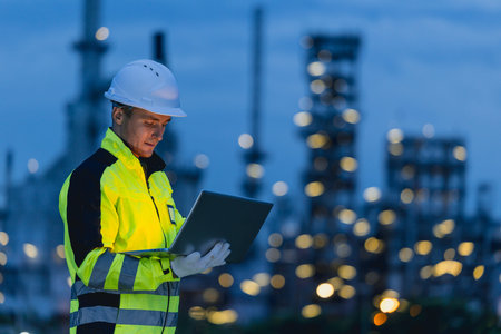 Engineer man technician male working at night shift with tablet technology device on site service...