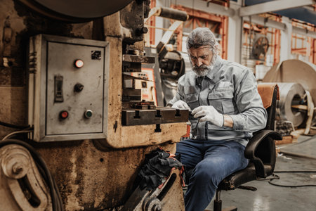 Elderly man hard working, senior old man skill labor master hand make metal work piece in heavy industryの写真素材