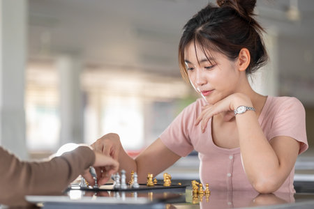 Smart students teen girl playing chess board game with friend at school campus leisure activityの写真素材