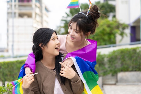 Women teen with colorful LGBTQ pride month rainbow flag, couple female happy smiling enjoy togetherの写真素材
