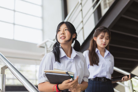 Smart students women teen in uniform with friend in modern school campus building. vision look for futureの写真素材