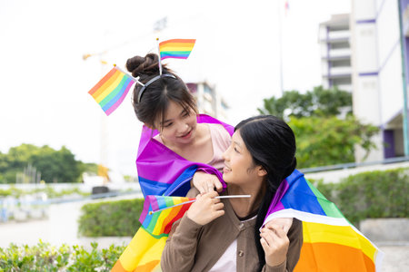 Women teen with colorful LGBTQ pride month rainbow flag, couple female happy smiling enjoy togetherの写真素材