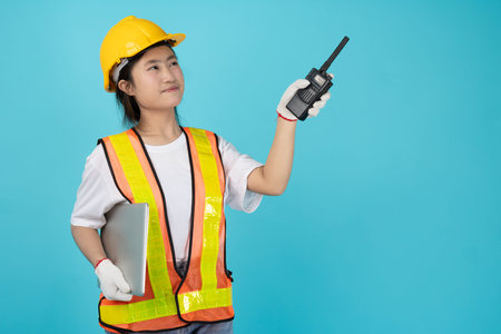 Portrait Engineer Woman Asian Teen with safety reflective vest isolated model using radio pointing at copy space