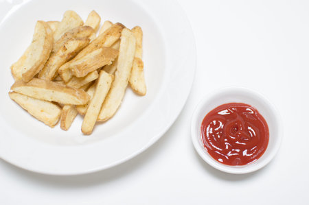 Potato chip and ketchup on white background