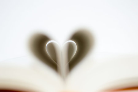 Pages of a book forming the shape of the heart on white background