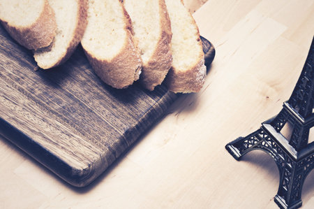 Sliced baguette bread on wooden plate
