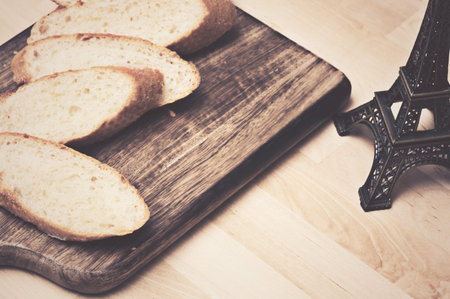 Sliced baguette bread on wooden plate with coffee