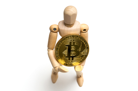Golden bitcoin and jointed doll on white backgroundの写真素材