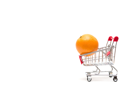 Orange and shopping cart on white background : economy conceptの写真素材