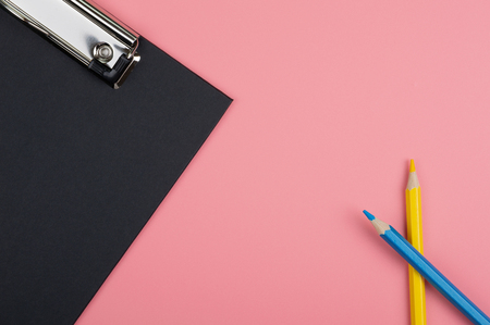 black clip board and color pencil on red backgroundの写真素材