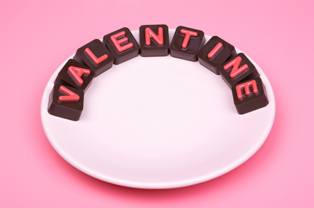 Valentine engraved in chocolate on colored backgroundの写真素材