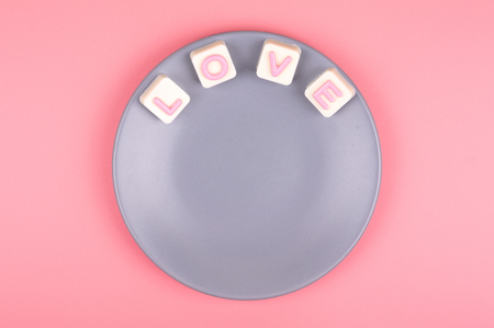 Love engraved in chocolate on colored backgroundの写真素材