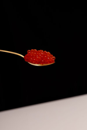spoon with caviar macro photo on black background golden spoon full of red caviar close-up photo