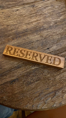 Wooden Reserved sign on a rustic wooden table.