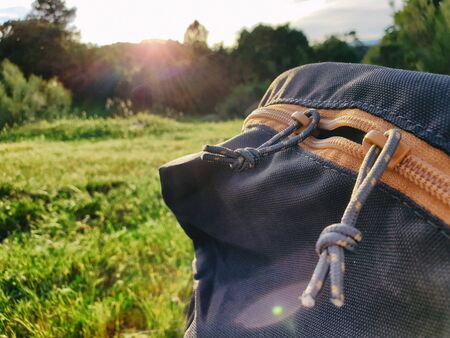 backpack zippers with grass and sunset on mountain backgroundの写真素材
