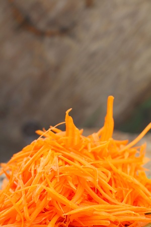 Grated carrot on a wooden plate の写真素材