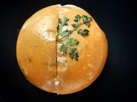 Bread with coriander on black background