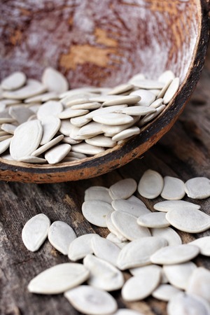Pumpkin seeds on wood backgroundの写真素材