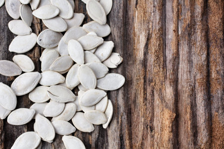 Pumpkin seeds on wood background