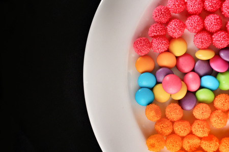 Mixed colorful candy on black backgroundの写真素材