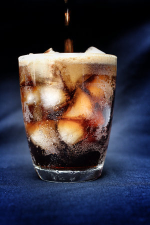 cola with ice cubes on  black background