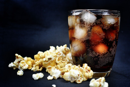 popcorn and cola on the black backgroundの写真素材