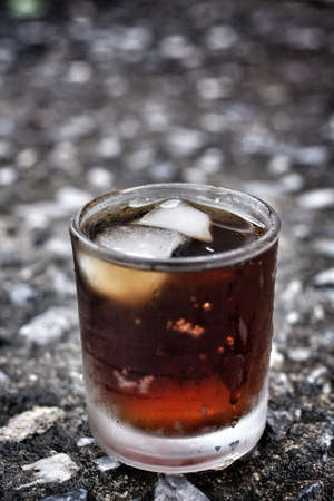cola with ice cubes on black の写真素材