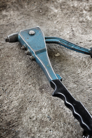 Pop rivet gun tool on gray background