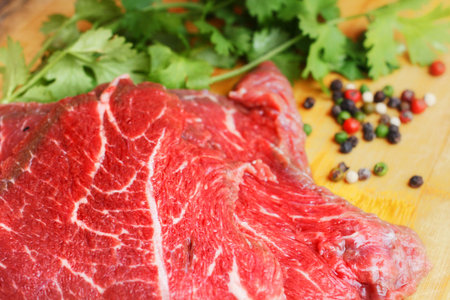 Raw beef meat ,coriander and pepper on cutting board