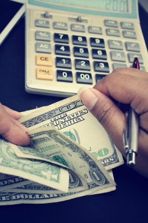 Counting dollar, calculator and pen