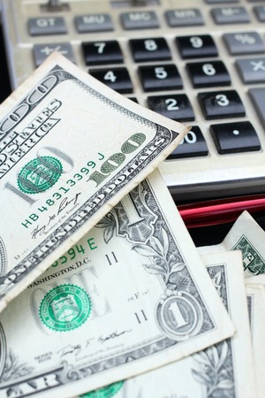 Counting dollar, calculator and penの写真素材