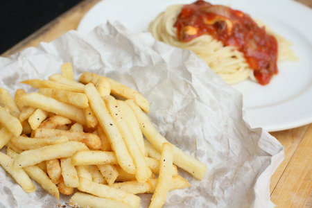 Close up of tasty spaghetti and french fries