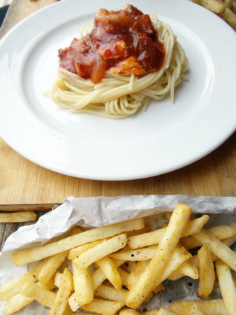 Close up of tasty spaghetti and french fries