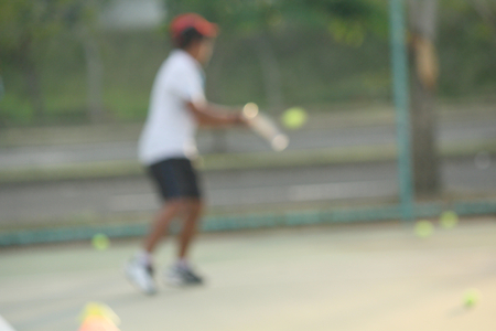 blurred of kid playing tennisの写真素材
