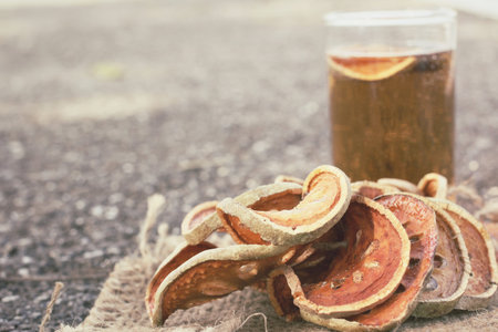 Slices of dried bael fruit and tea