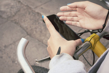woman using smart phone on bikeの写真素材