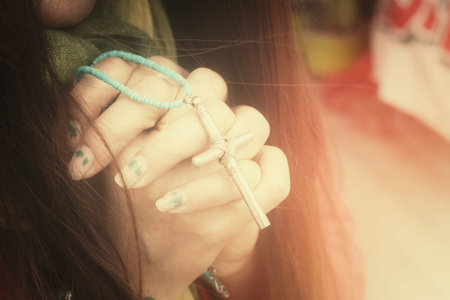 Woman hands praying with cross